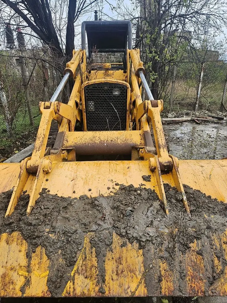 Buldozerul John Deere văzut din față, cu cupa frontală cu dinți